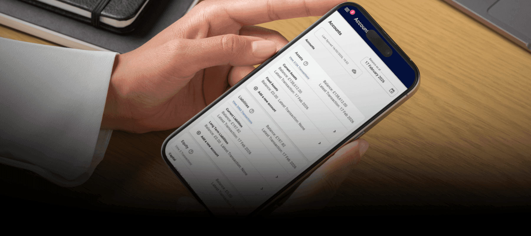 Holding a mobile phone displaying the Accounts section of Squeegee's MTD features